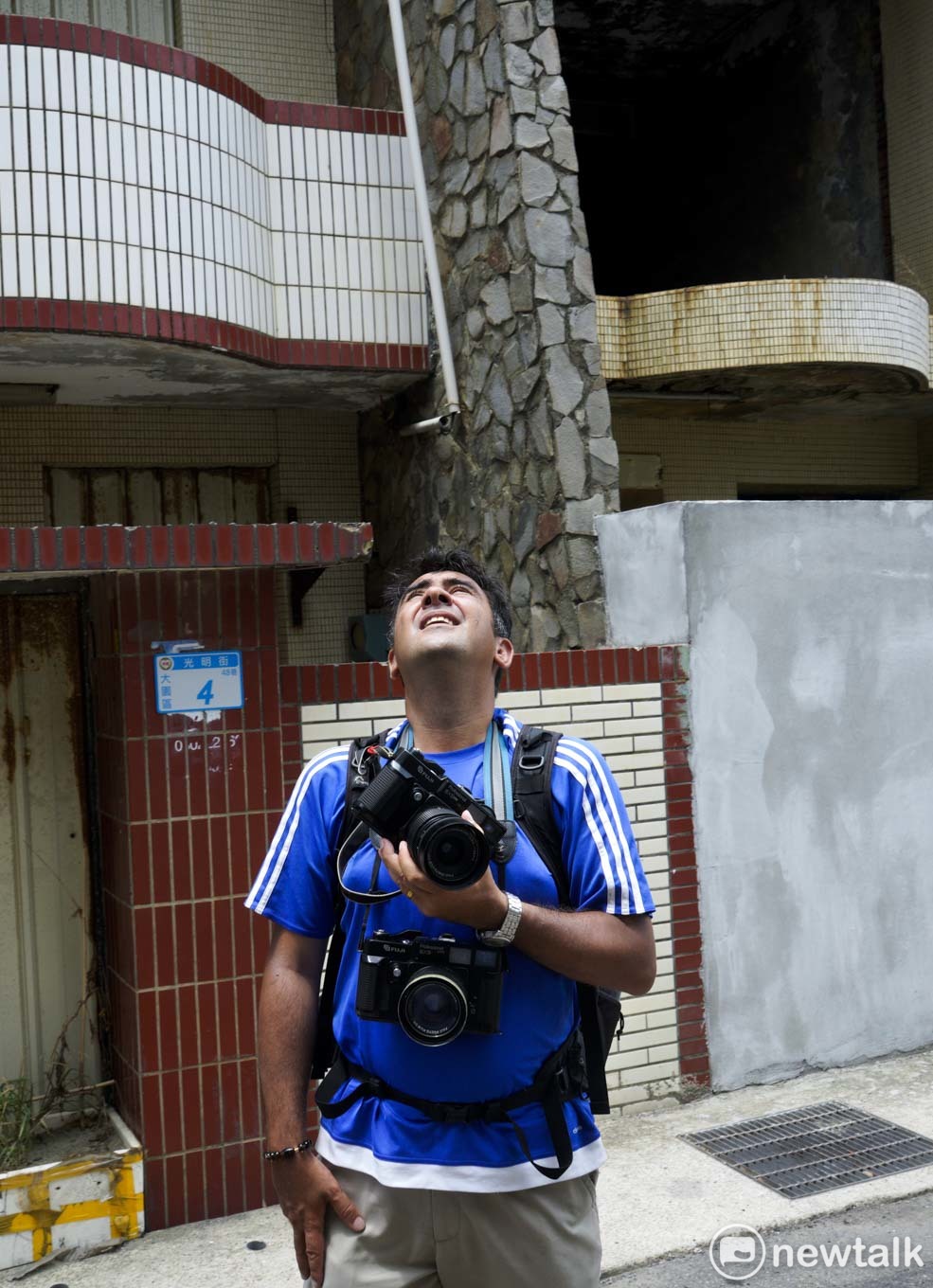 余白在桃園大園區看到80年代建築風格的住家，他手上拿著6x9的底片相機，等待被雲層遮住的陽光。他說，攝影是他的一切，為了等待光線而耗去一個鐘頭的時間是值得的。 圖：張良一/攝