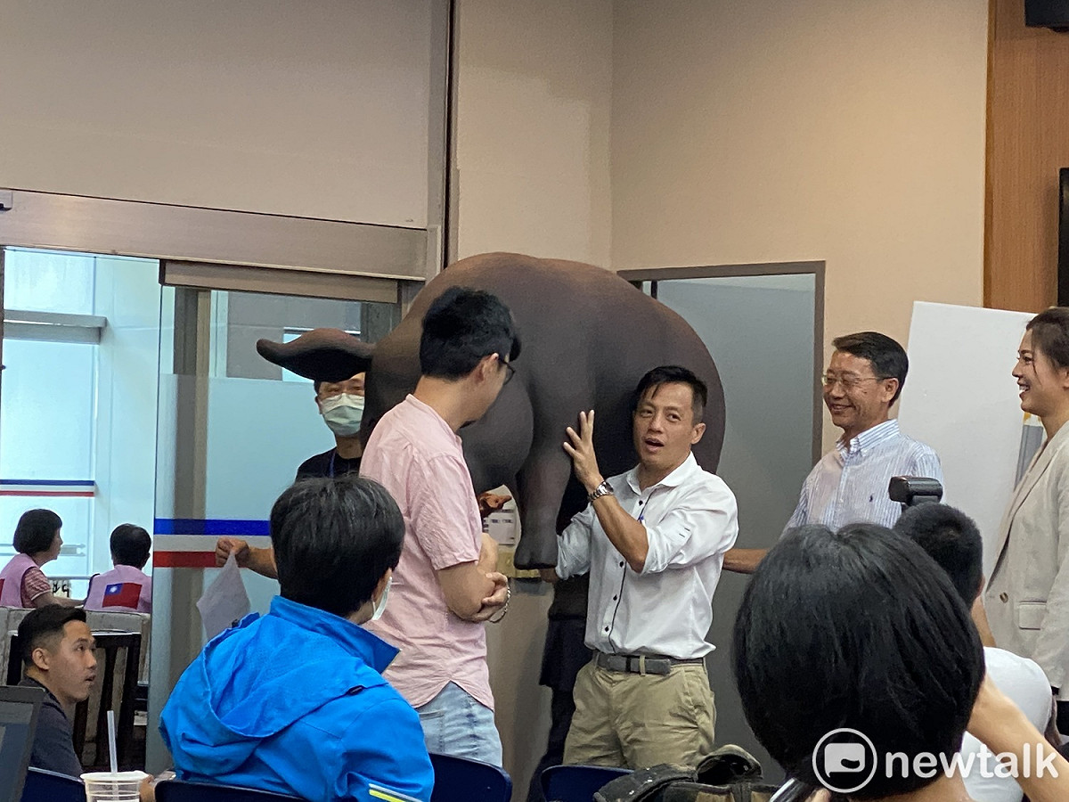 記者會結束後，國民黨市議員李明賢扛著黑毛豬模型離開現場。 圖：周煊惠 ／攝