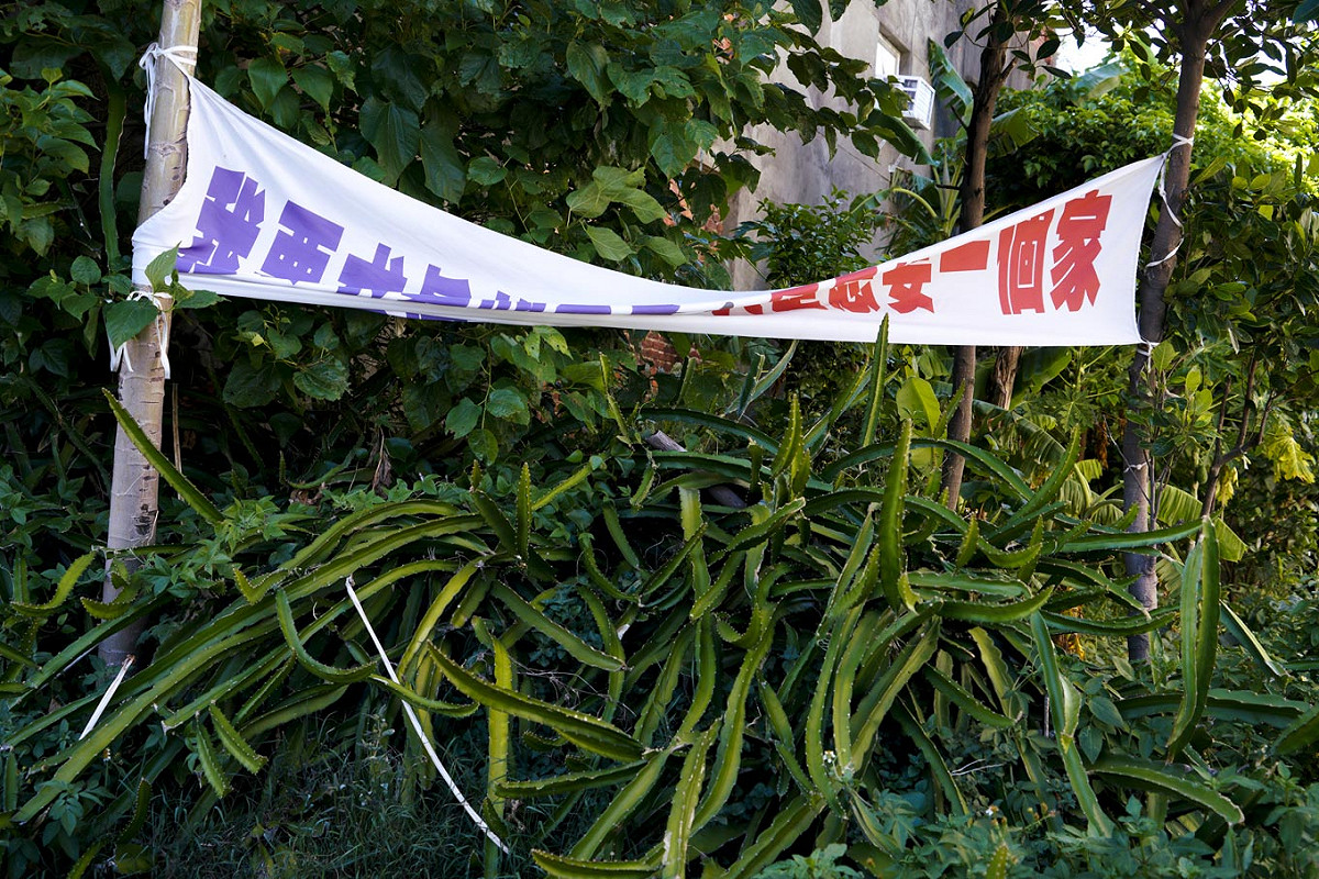 大園區一戶人家在菜園外懸掛『我要求真的不多，只是想要一個家』抗議布條。 圖：張良一/攝