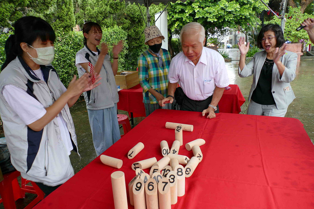 民眾挑戰撞柱遊戲，衛生局長陳潤秋於一旁加油。  圖：新北市衛生局 / 提供