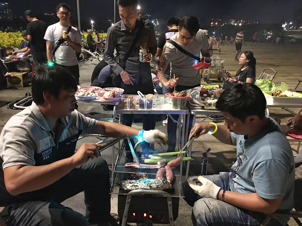 兩位「主烤官」賣力的為朋友們燒烤各式海陸大餐。 圖：張良一/攝