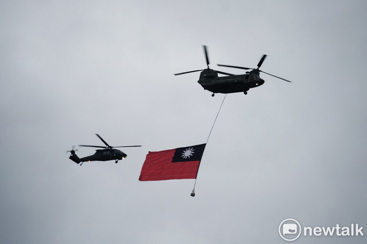 兩架CH-47SD直升機懸掛兩幅巨型國旗和7架UH-60M直升機在上午7:01首先通過總統府前上空。 圖：張良一/攝