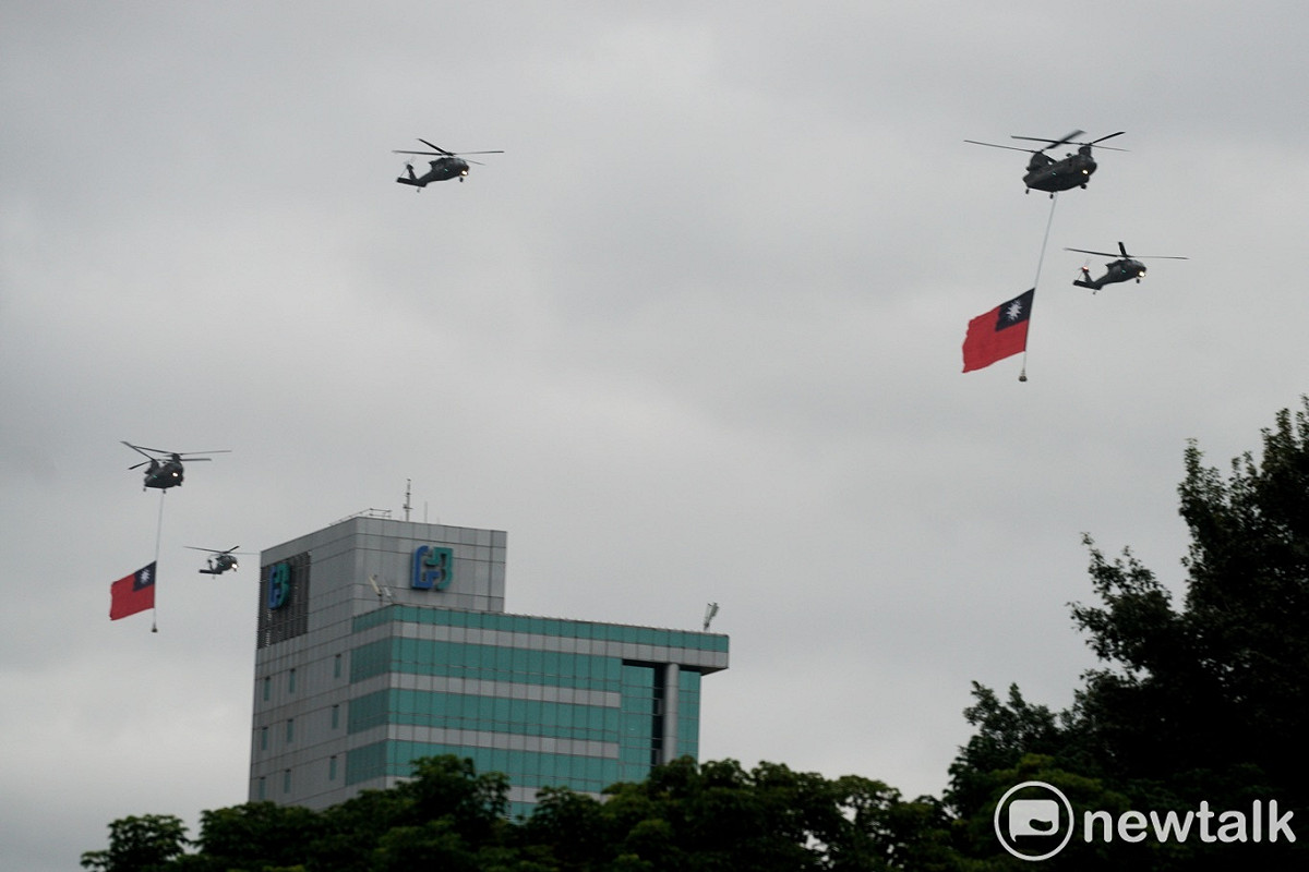兩架CH-47SD直升機懸掛兩幅巨型國旗和7架UH-60M直升機在上午7:01首先通過總統府前上空。 圖：張良一/攝