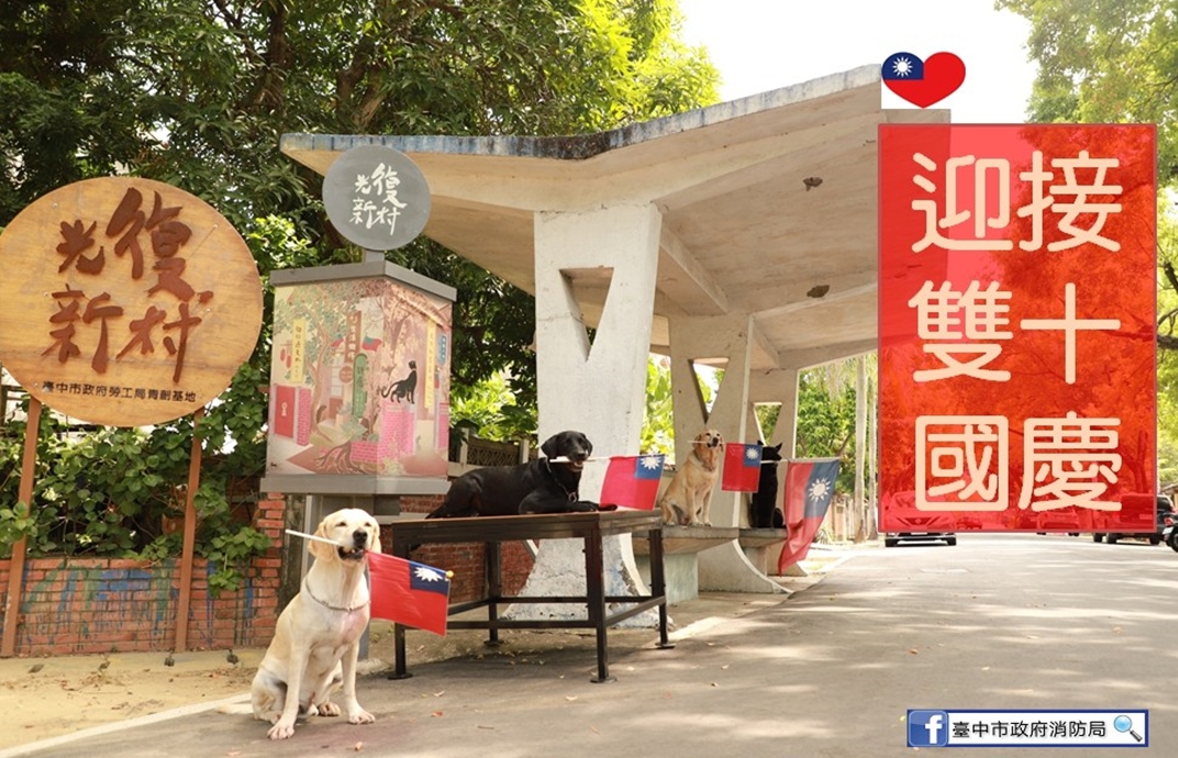 救難英雄腿腿、斯斯、Jacob、鐵雄等搜救犬叼著國旗排排站，看著青天白日滿地紅的國旗緩緩升起，一起祝賀「雙十國慶 普天同慶」。 圖:台中市消防局/提供