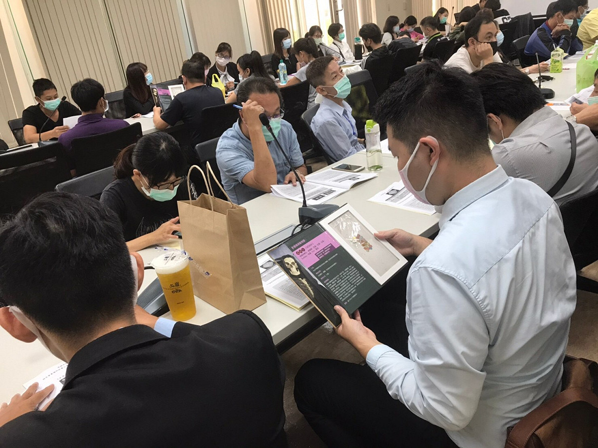 場所業者代表輪流傳看仿真毒品。 圖:高雄市政府提供