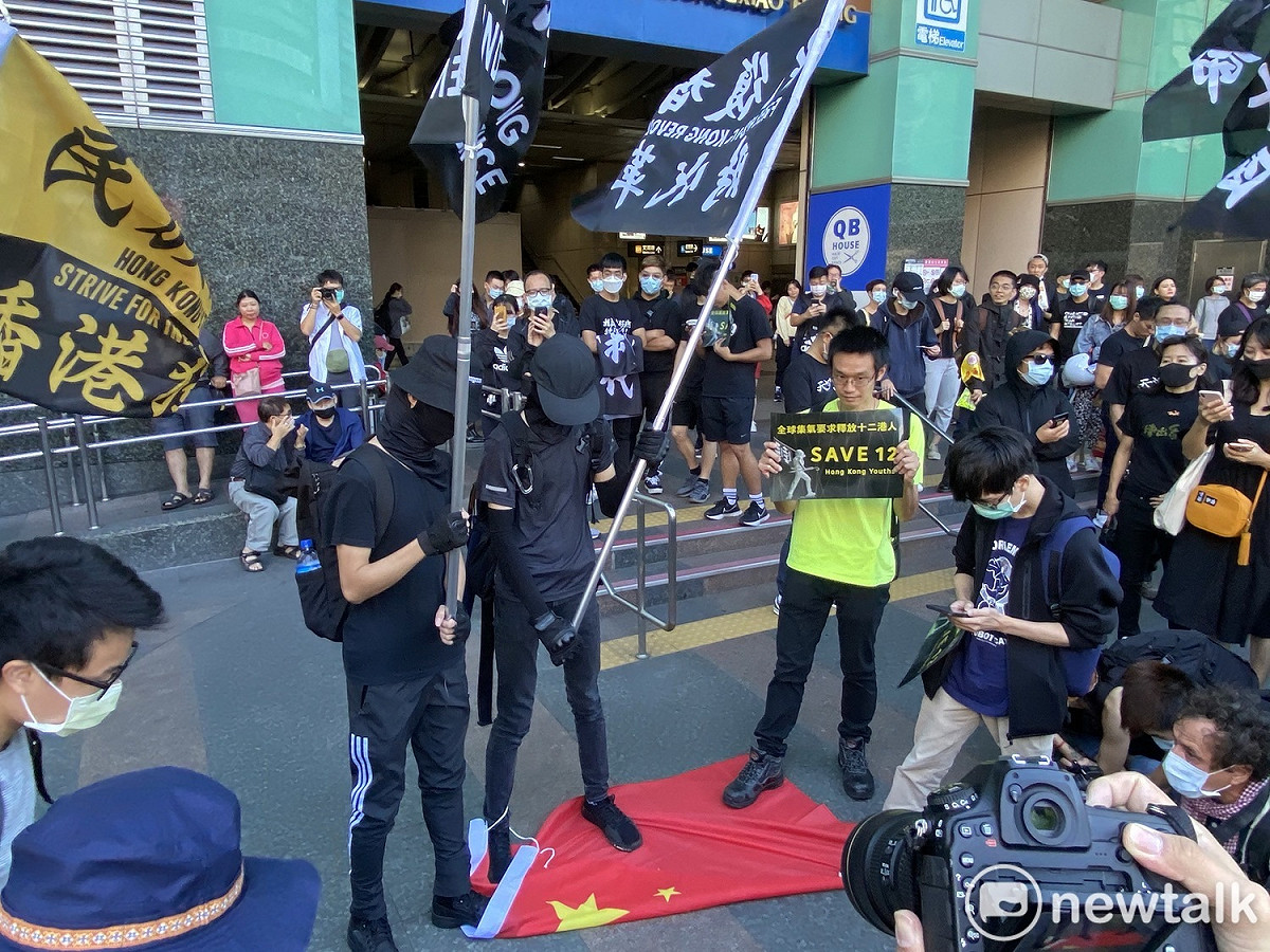 遊行民眾手持「光復香港，時代革命」旗幟，腳踩中國五星旗。 圖：周煊惠／攝