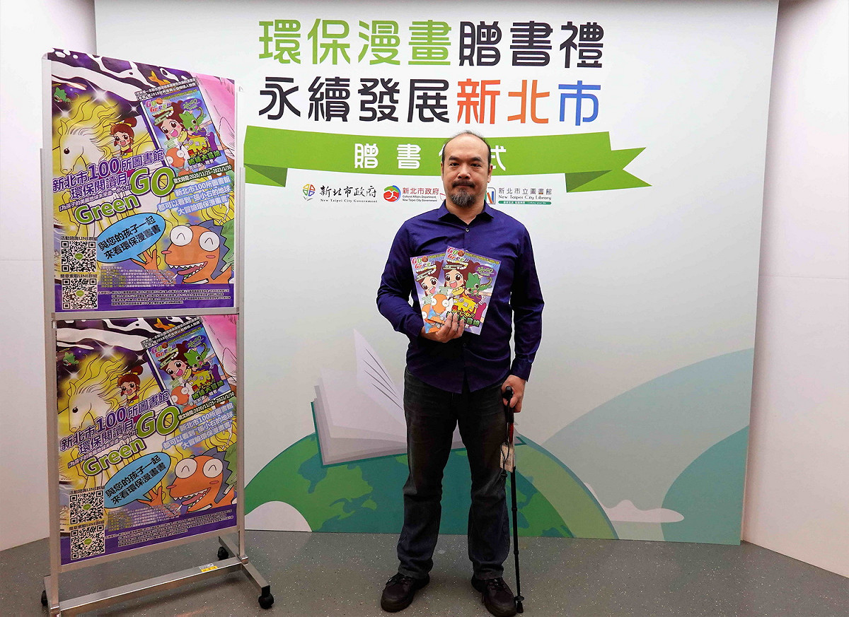 環保公益漫畫家黃志湧雖中風行動不便，仍不忘公益，贈送 100冊自己創作的「世界第一本聯合國環保報告知識漫畫」給新北市立圖書館。 圖：王峻昌／攝