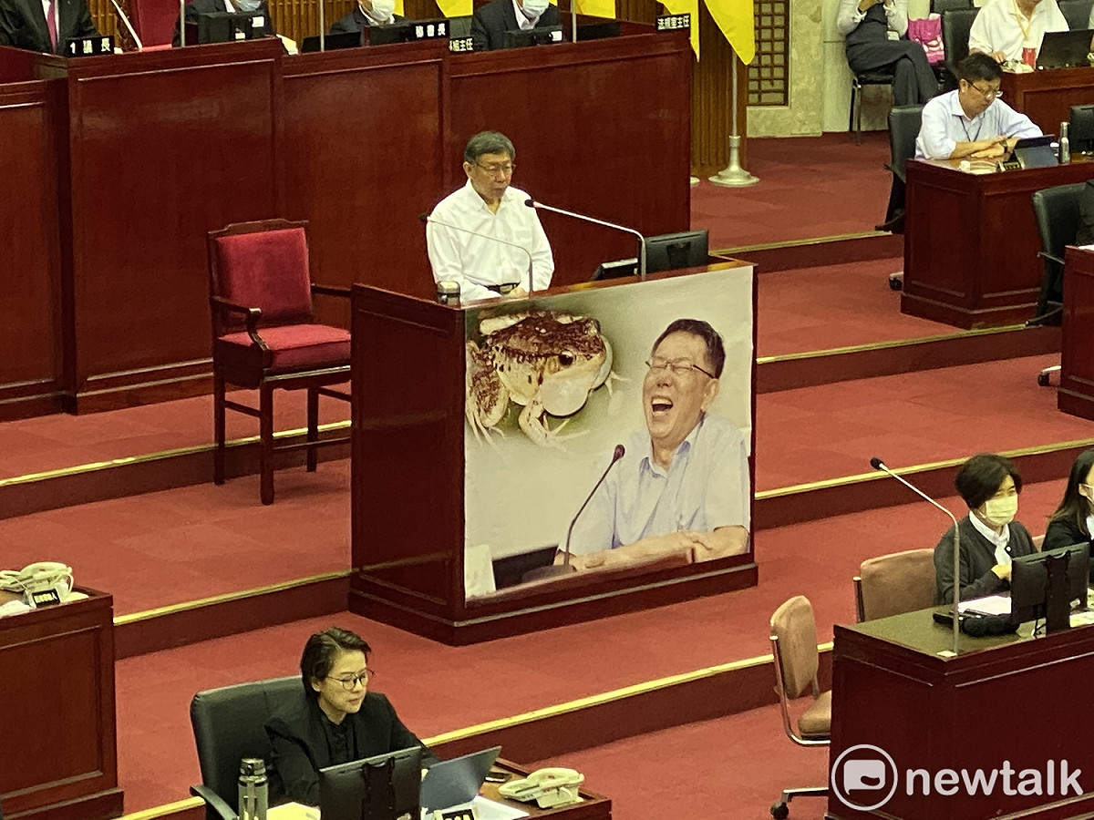 台北市長柯文哲的備詢台被張貼青蛙「膨風」跟柯的合成照。 圖：周煊惠 ／攝