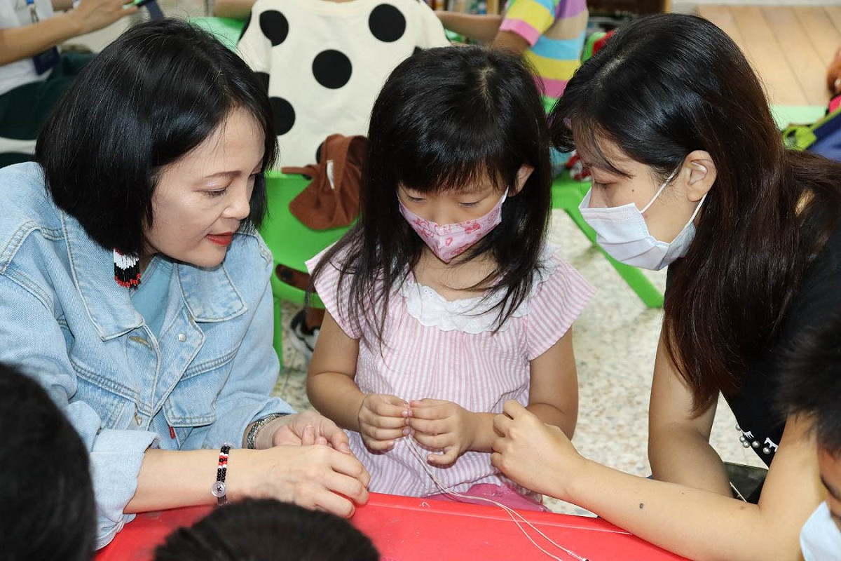 原民局長羅美菁(左)到場與小朋友們一起製作原住民族串珠手鍊，並與現場小朋友們一起互動  圖：新北市原民局提供