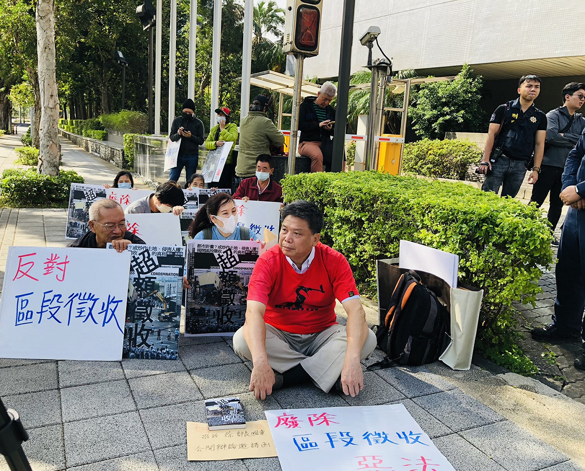 政大地政系教授徐世榮和陳情民眾無奈的坐在地政節66週年慶祝大會場外的樓下等待官員出來。 圖：謝莉慧/攝