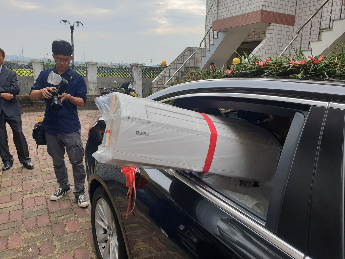 嘉義縣大林鎮昨天舉行的一場婚禮中，新娘從禮車上丟出一台冷氣機。 圖：攝影師洪年宏/提供