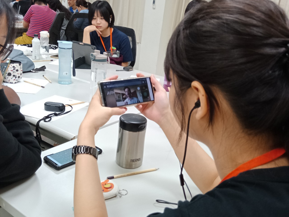 志工團透過手機視訊與SVA 會長互動。 圖：高雄市政府/提供