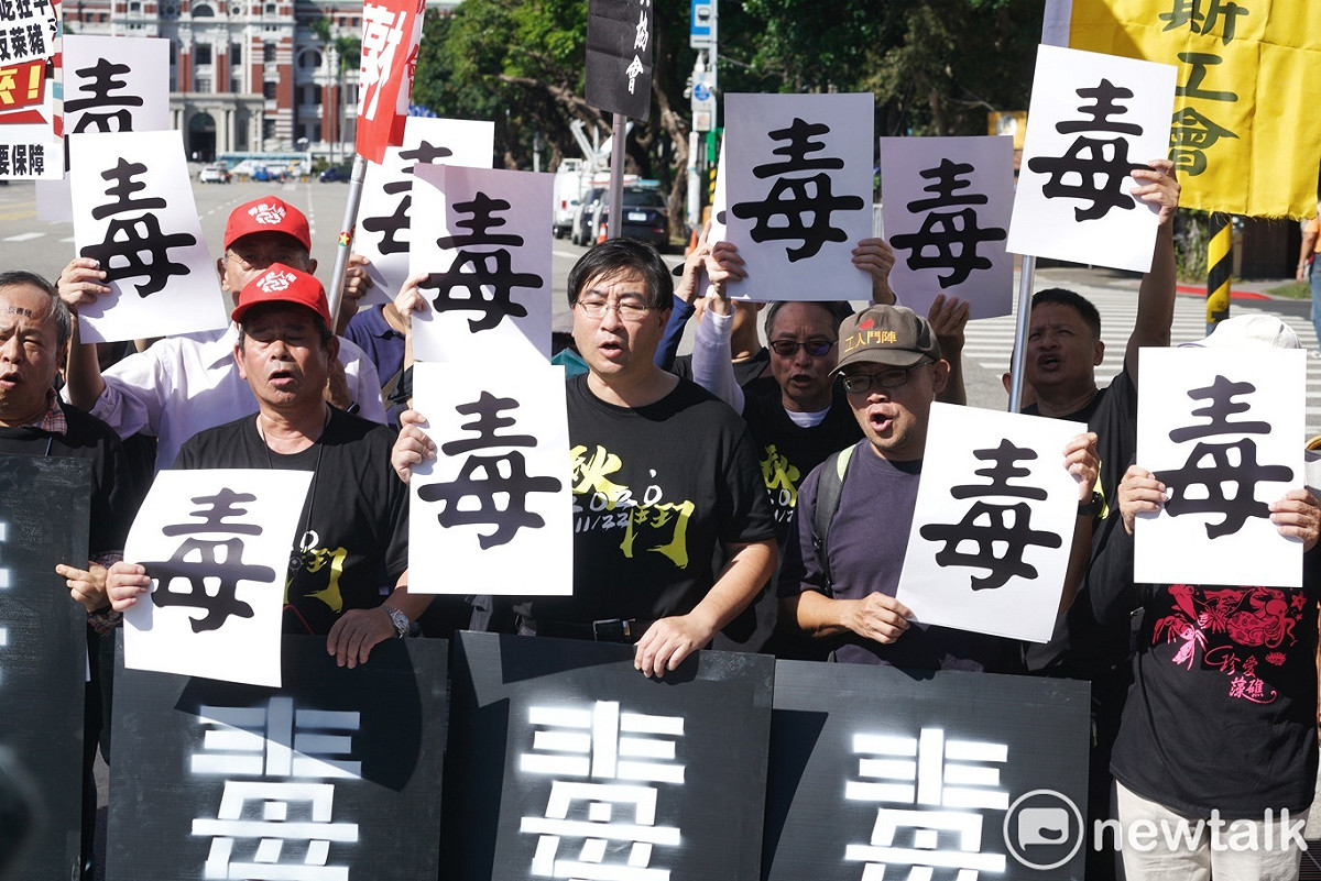 秋鬥主辦團體的成員在記者會中拿出「毒」字，反美豬進口。 圖：張良一/攝