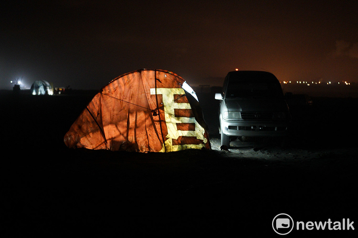 入夜後，一個用建案廣告帆布包覆的魚寮亮起燈火。 圖：張良一/攝