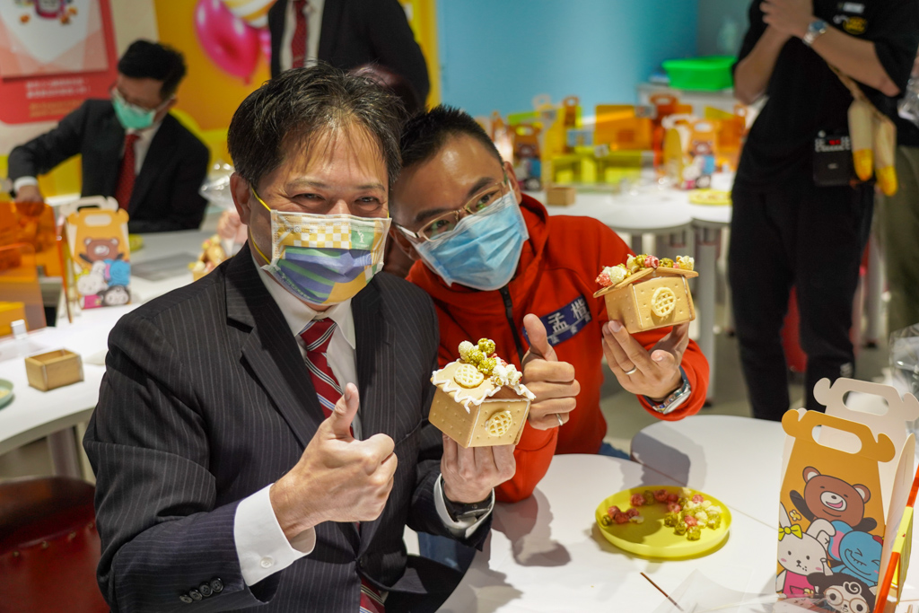 新北市副市長吳明機、立委洪孟楷 (右)體驗卡滋爆米花觀光工廠薑餅屋DIY。 圖：新北市經發局提供