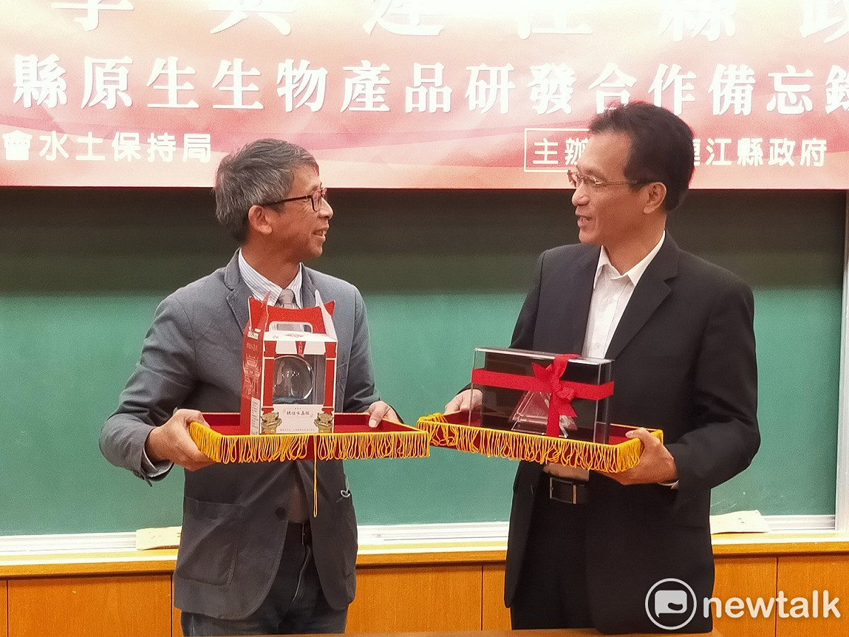 連江縣政府產業發展處長王建華與亞大產學長林田富簽署備忘錄後互換禮物。 唐復年/攝