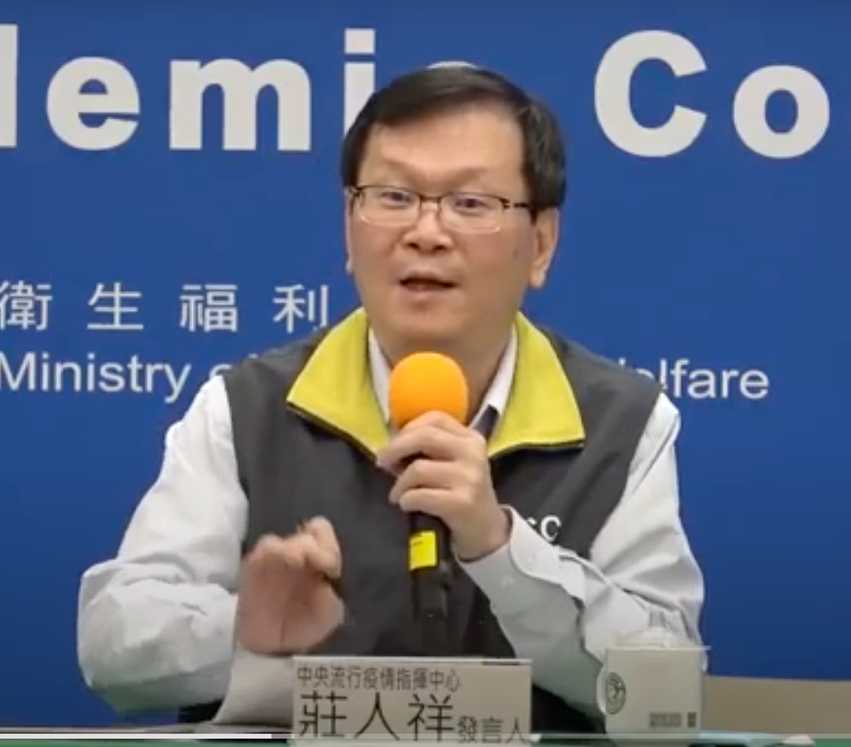 指揮中心發言人莊人祥，說明案689被毒蜘蛛咬傷後又染疫一事。 圖：翻攝自指揮中心影片
