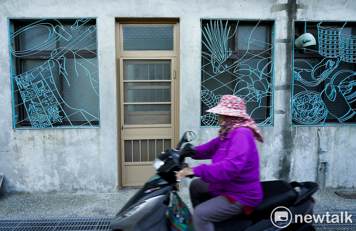 一位阿嬤騎車機車經過椬梧調天宮附近有著美麗鐵花窗的民宅。這些鐵花窗剛完工不久，負責鐵花窗設計的芃芓藝術工作室設計師蔡佳吟表示，鐵花窗兼具實用、美觀與情感連結，訴說著椬梧的人文故事和農漁特產，而負責此次椬梧城鎮之心人文景觀再造計畫的呂耀中也說，透過居民參與，希望能追求更適合農村的空間美學。 圖：張良一/攝