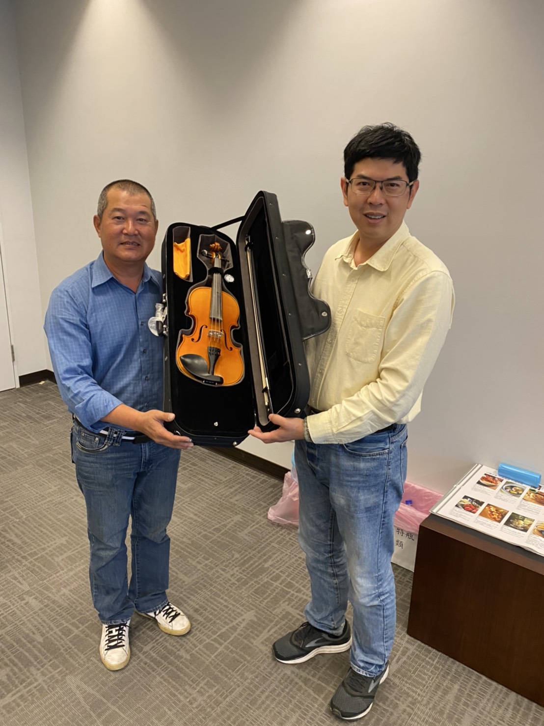 周永鴻將王世堅出借的小提琴交給羅父。 周永鴻/提供