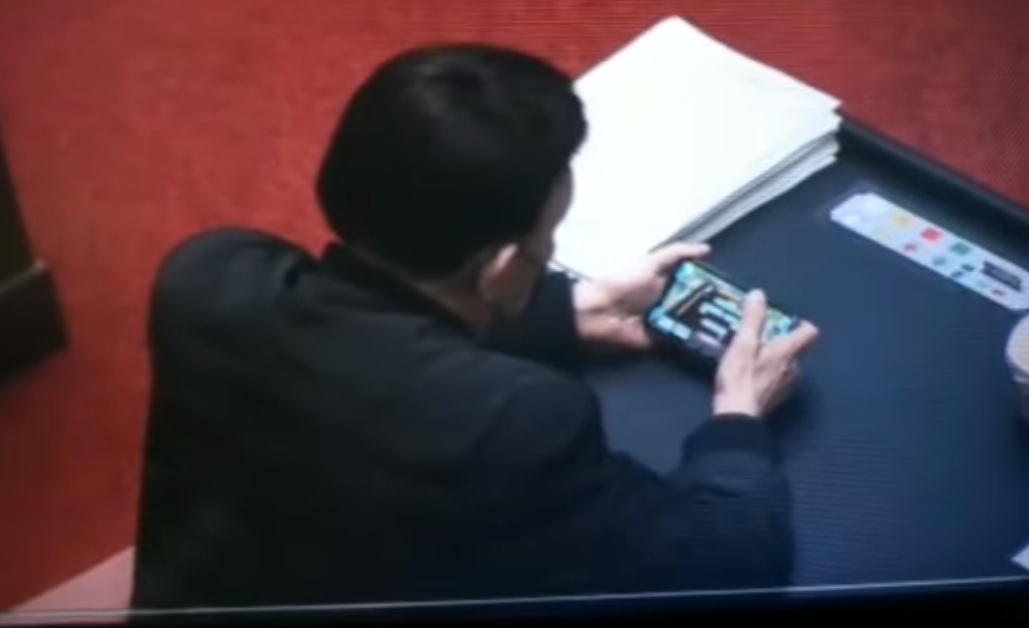 羅友志在YouTube貼出一段影片，畫面中民進黨立委余天在立院議場表決時，在座位上玩手機麻將。 圖:翻攝自羅友志YouTube