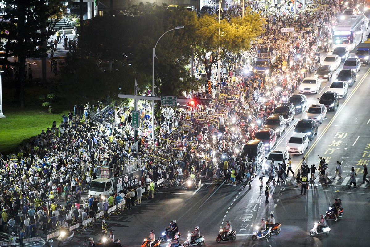 數萬名民眾高舉巨型的民主黃絲帶，參加罷免投票前夕的反恐大遊行，人潮擠爆遊行行經路線，場面相當壯觀。遊行過程中，不斷有市民加入遊行隊伍中。 圖：張良一/攝