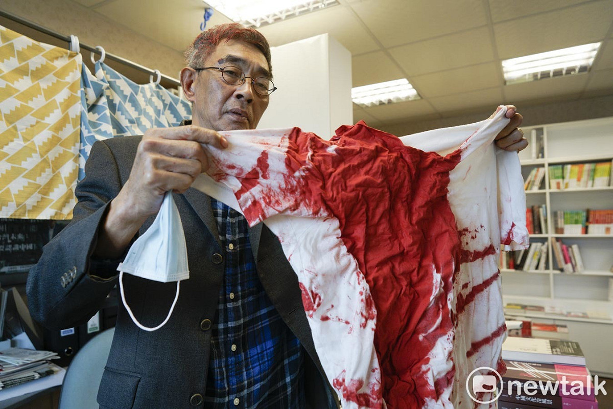 中山銅鑼灣書店負責人林榮基出示日前被潑灑紅色油漆的上衣，令人觸目驚心。 圖：張良一/攝
