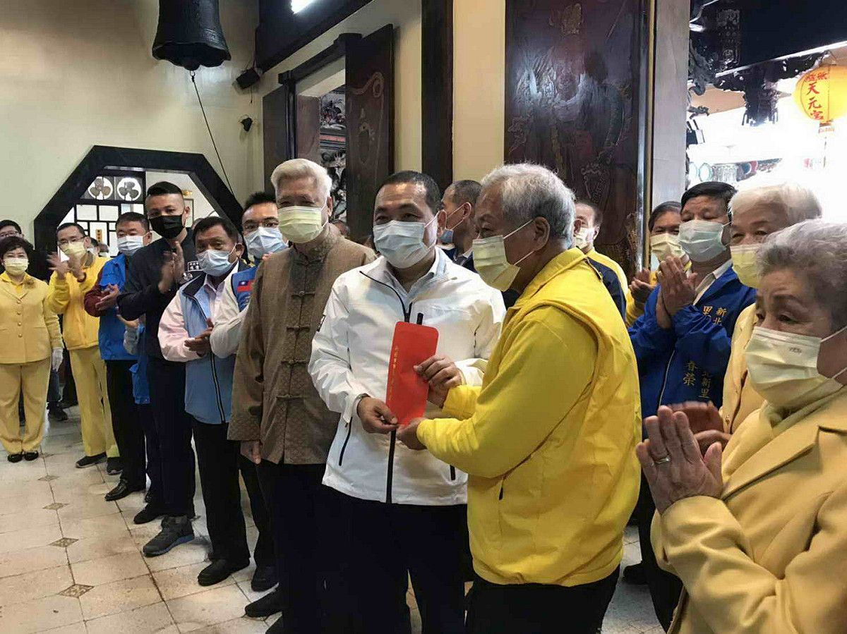 侯友宜前往淡水無極天元宮參拜並添香油錢，由董事長周志達 (右)代表接受。 圖：新北市民政局提供