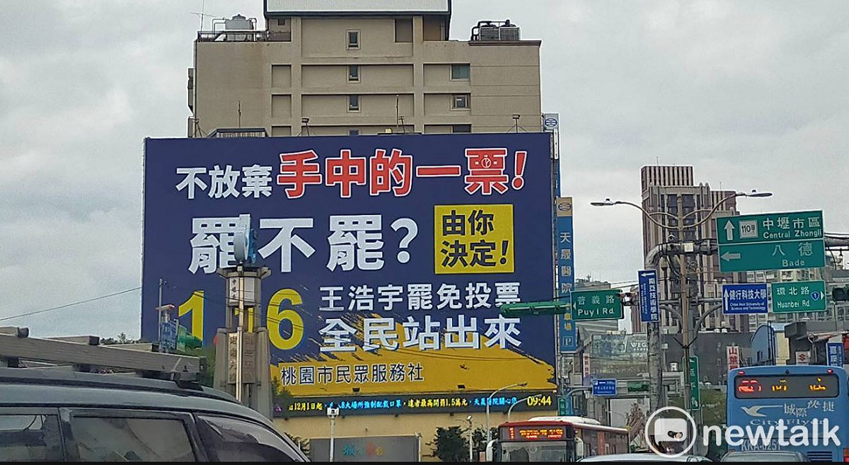 國民黨黃國園黨部在中壢七大路口掛上大型看版，呼籲中壢人站出來，1/16別忘了罷王投票。 圖：林昀真/攝