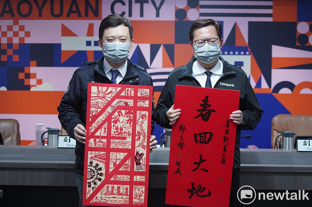 桃園市長鄭文燦與市府秘書處處長顏子傑一同秀出辛丑牛年春聯「心願滿地 犇向2021」及「春回大地」。 圖：林昀真／攝