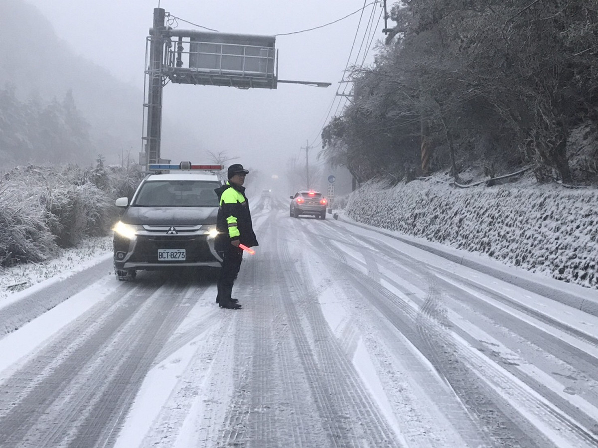 台中市與宜蘭縣交界處的「思源埡口」今（8）日清晨飄起白雪，和平警方在雪中執勤。 和平警分局/提供