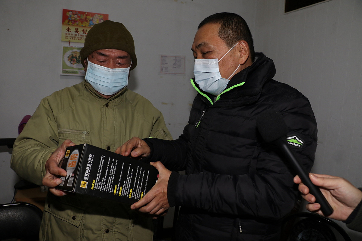 侯友宜送給阿榮一隻保溫熱水瓶 提醒他睡前要裝滿熱水放在床頭。 圖：新北市社會局提供
