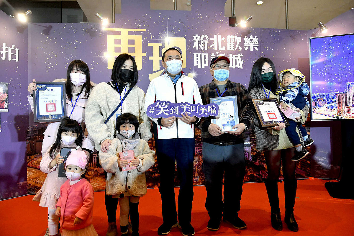 新北市長侯友宜在攝影展開幕展頒獎給「再現新北耶誕攝影大賽」得獎者，親手抽出Gogoro、iPhone12 promax等大獎，大讚參賽者創意無限。  圖：新北市新聞局提供