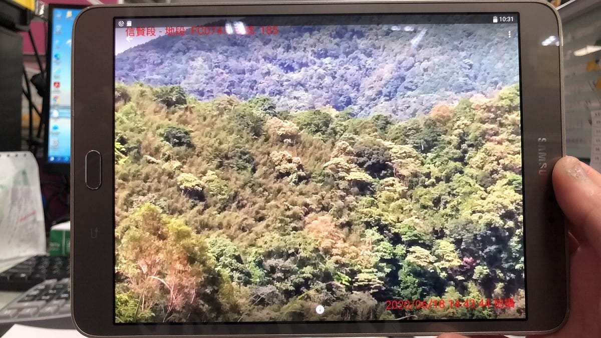 檢測員運用掌上型電腦之影像地籍圖整合資料至林地現場勘查辦理禁伐補償地段號之「定位、搜尋、量測距離、面積計算」等檢測作業。 圖：新北市原民局提供