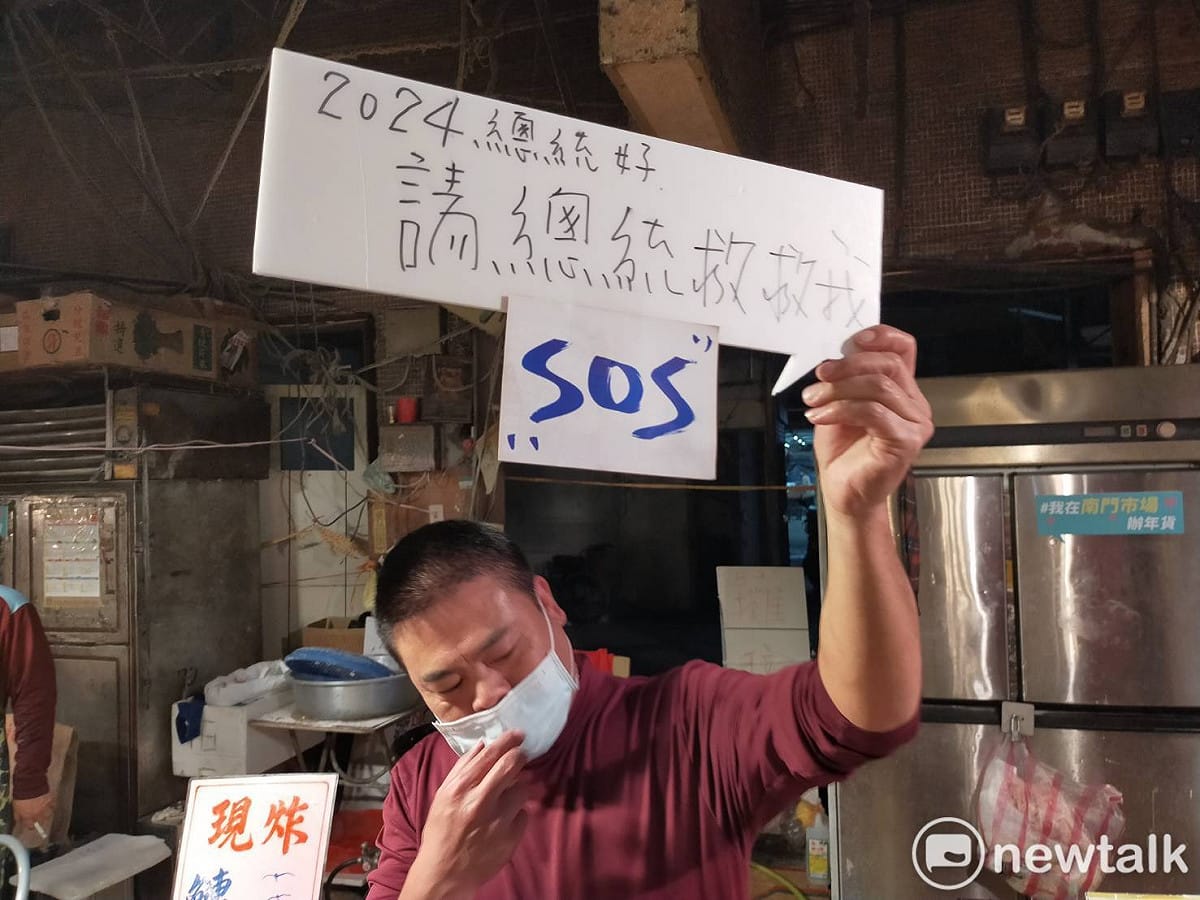有攤商手持標語寫著「2024總統好，請總統救救我」，希望鄭文燦能幫忙帶來人氣，讓南門市場的買氣回升。 圖：林昀真／攝