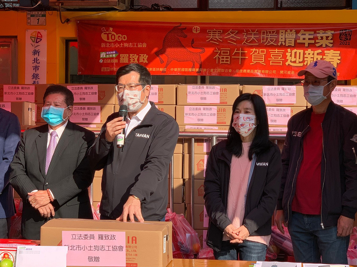 立委羅致政 (持麥克風者)、新北市小土狗志工協會及板橋東區扶輪社今天舉辦「寒冬送暖贈年菜、福牛賀喜迎新春」公益活動。 圖：羅致政服務處提供