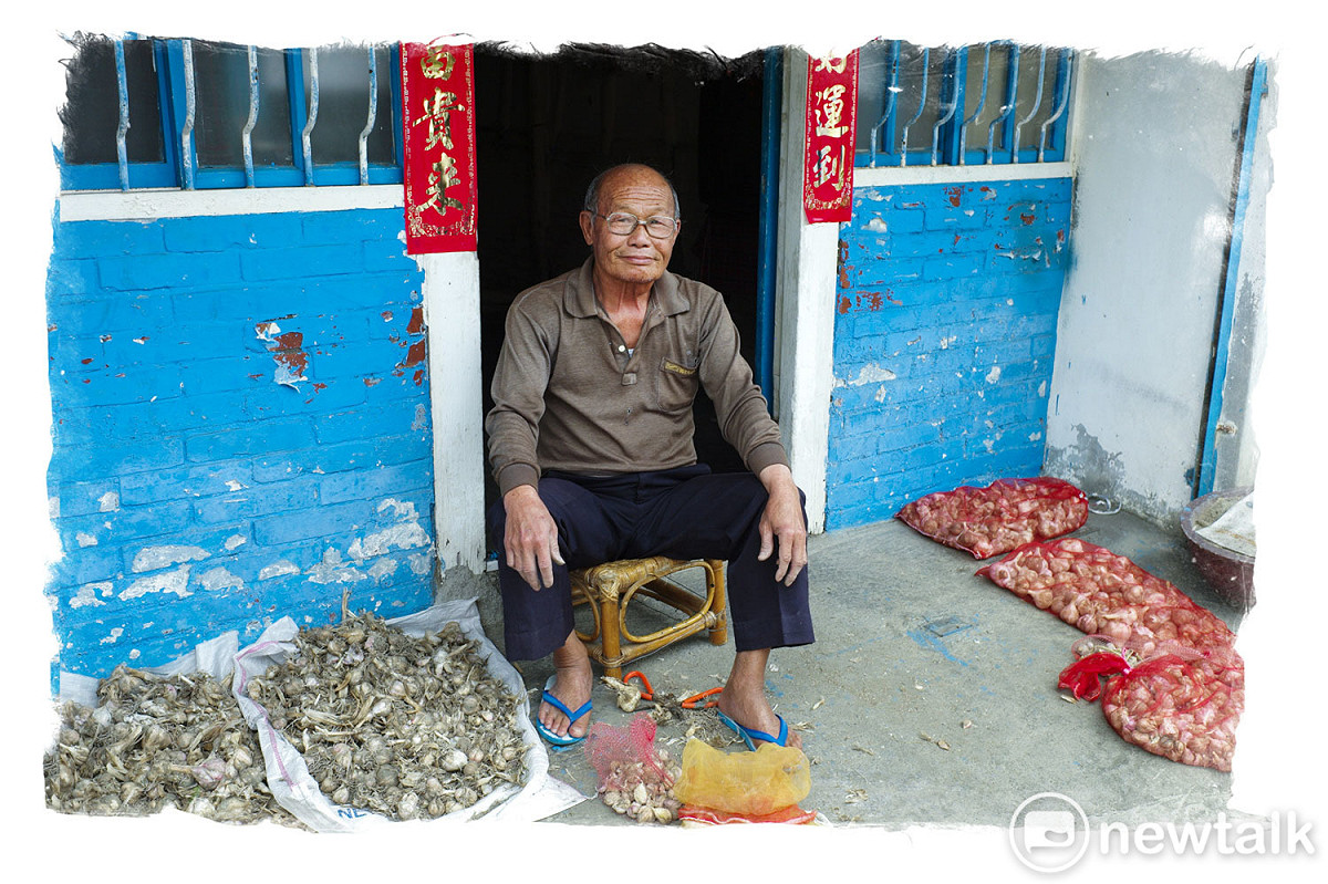 雲林縣土庫鎮一位鎮民在他的住家門口曬著滿滿的蒜頭。蒜頭採收季節時，土庫鎮幾乎家家戶戶都在曬蒜頭。近幾年，蒜頭價格居高不下，蒜頭變成非常受歡迎的伴手禮，許多農村村民會將曬乾的蒜頭送給遠方的親友。 圖：張良一/攝