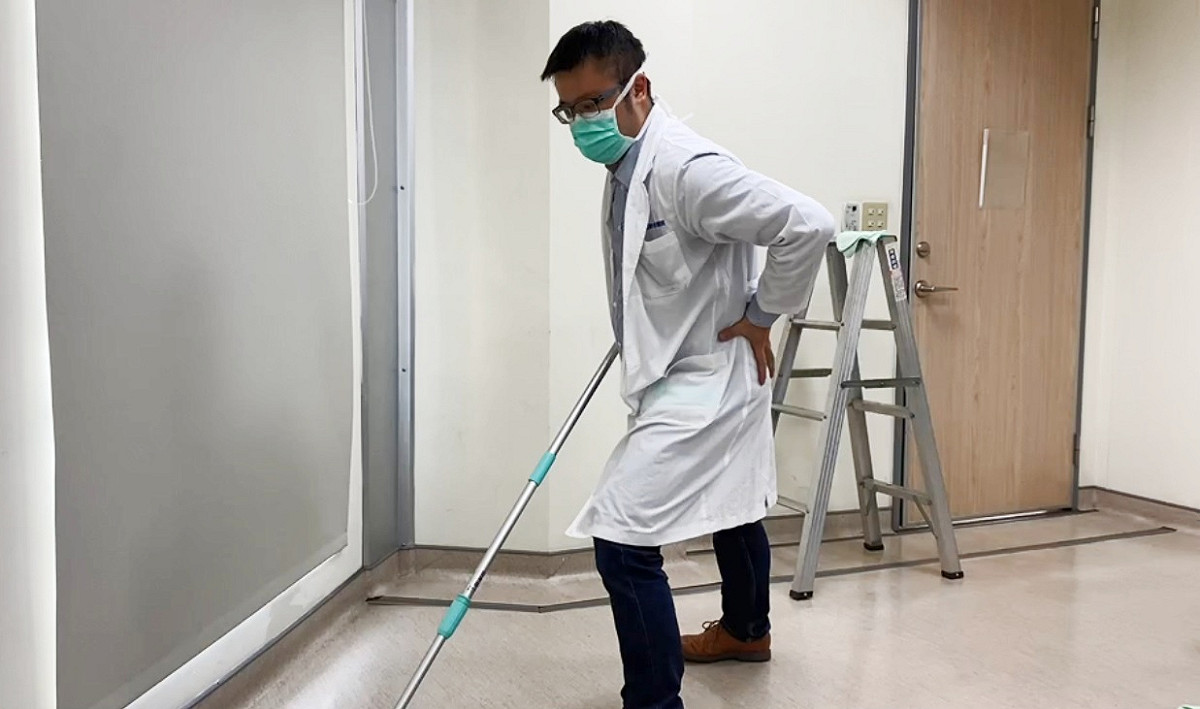 光田綜合醫院骨科醫師嚴可倫示範使用拖把動作，減少反覆彎腰。 光田綜合醫院/提供