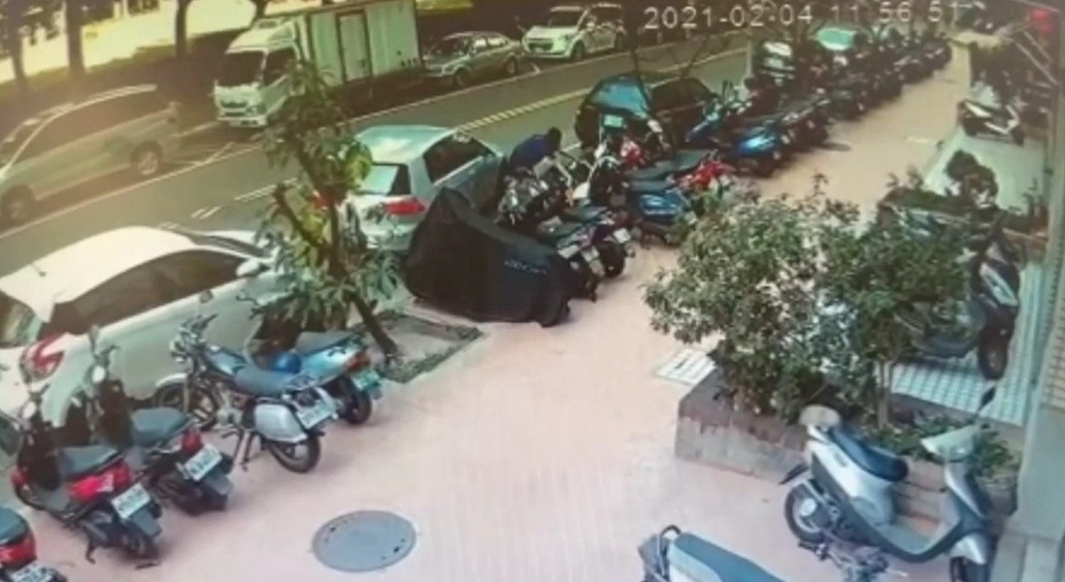 女子擅自將停車格上的重機移開，卻不慎把重機推倒在地。 圖：翻攝爆怨公社臉書