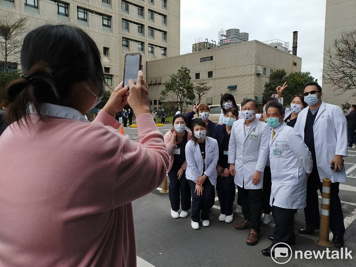 各科部的醫師、護理師或行政人員在場邊拿著手機合影，紀念今天的重啟活動。 圖：林昀真／攝