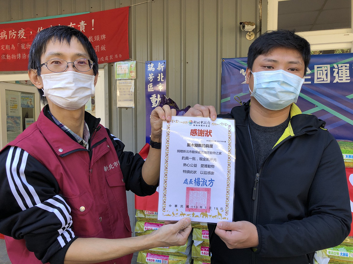 瑞芳動物之家獸醫王嚴緒（左）致贈感謝狀給「大漁丸愛心專班」成員。 圖：新北市動保處提供
