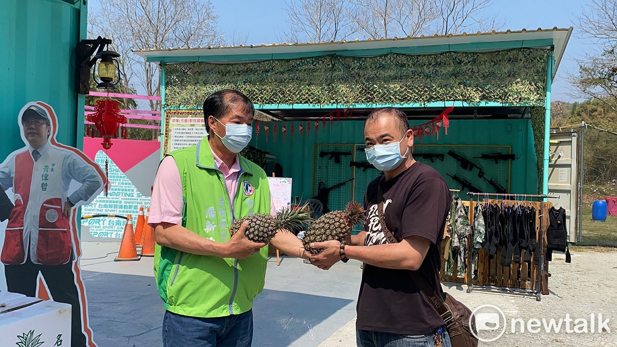 民進黨台南市黨部號召柳營靶場負責人蔡岳勳認購一萬顆鳳梨，來靶場即免費送，不只力挺農民，也趁機宣傳射擊運動。 圖：黃博郎／攝