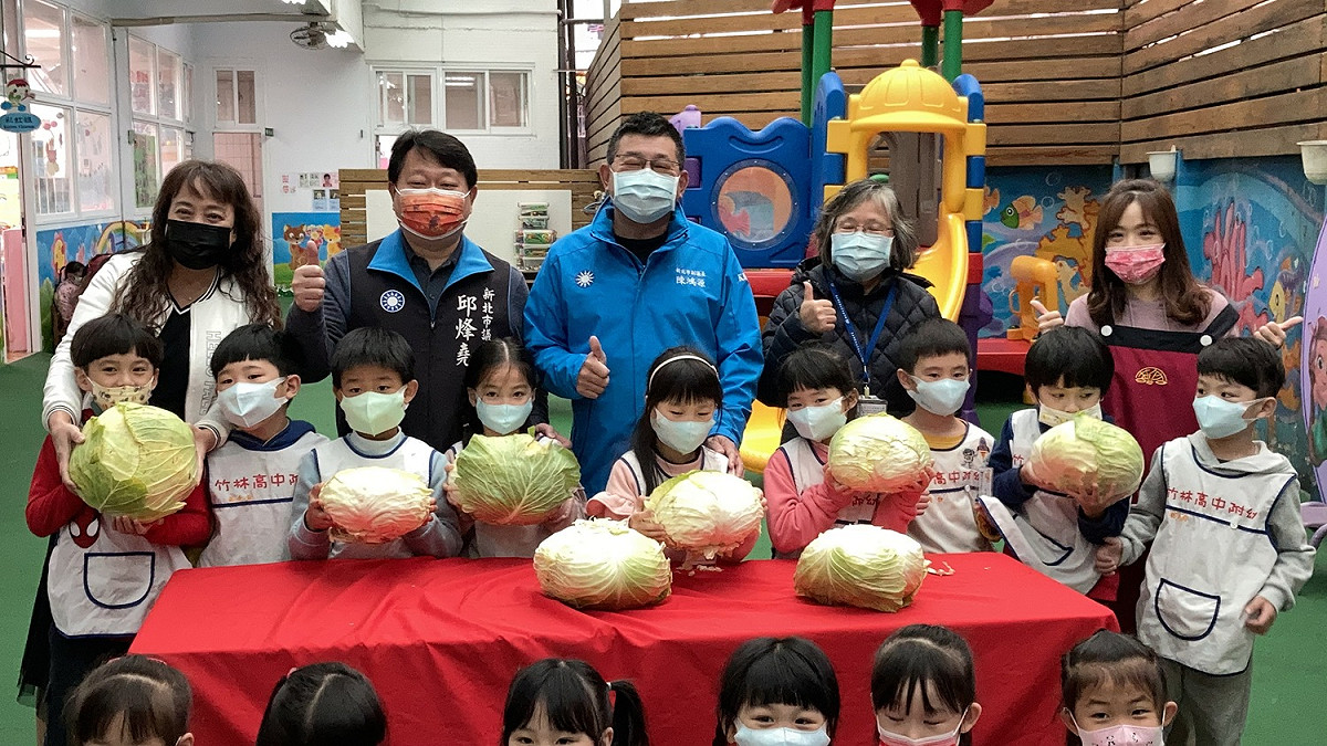 竹林附幼的小朋友參與高麗菜義賣，左起依次為竹中附幼園長李錦燕、市議員邱烽堯、副議長陳鴻源及竹林中學校長顏麗珠。 圖：竹林中學提供