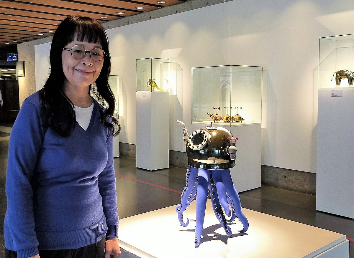 陶藝家張麗娟近日在鶯歌陶瓷博物館舉行個展，《戴潛水頭盔的章魚》，仔細從金屬感的潛水頭盔鏡頭往內看，映入眼簾的海底世界彩繪陶板，讓人會心一笑。 圖：鶯歌陶瓷博物館提供