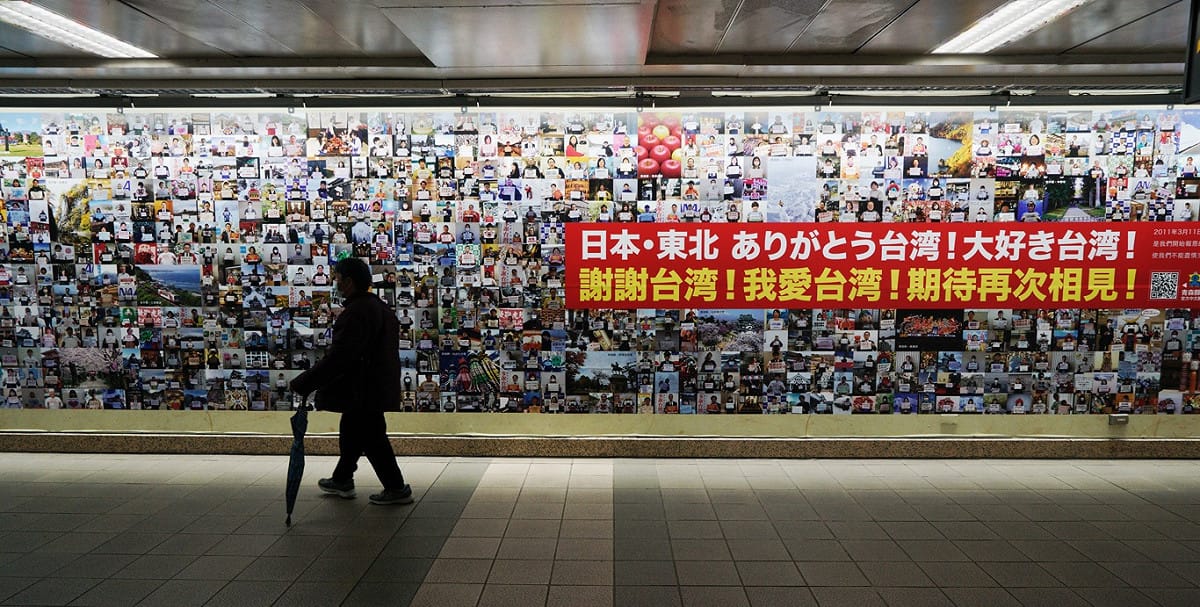 一位民眾經過展示日本東北民眾感謝台灣的照片牆。 圖：張良一/攝