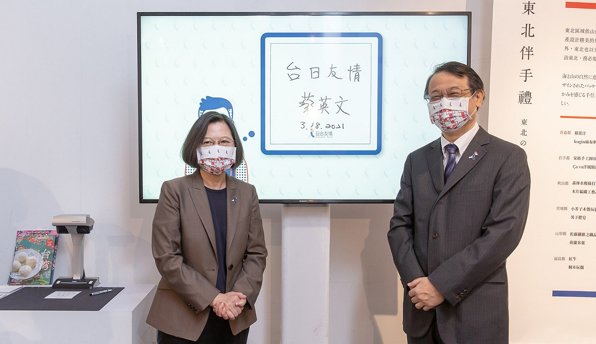 總統蔡英文18日出席在華山文創園區「311十周年東北友情特展 」，在日本台灣交流協會代表泉裕泰陪同下，在留言板上留下「台日友情」文字。 圖：總統府提供