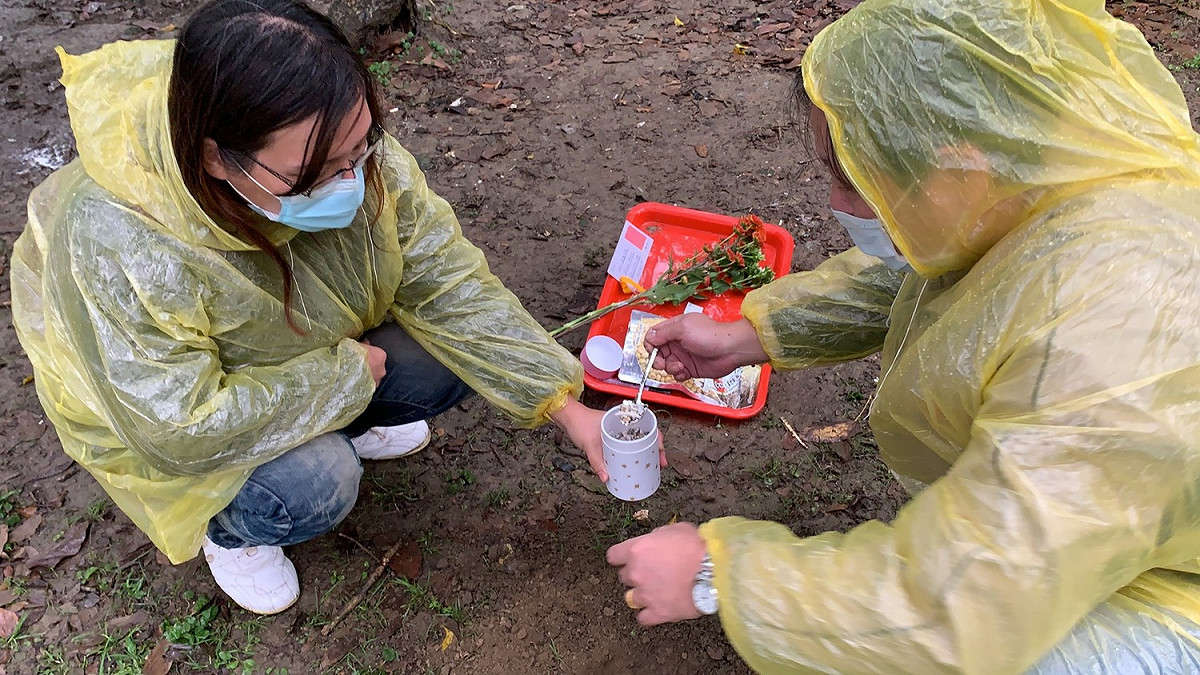 毛寶貝的家長用動保處樹葬特製小鏟子，將毛寶貝的骨灰挖至洞中。   圖：新北市動保處提供