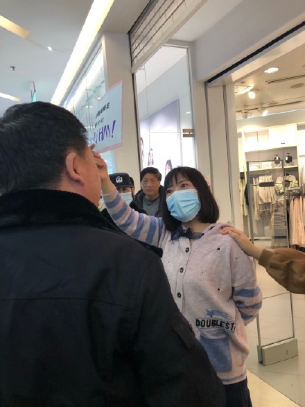 一名女子在H&amp;M門口舉牌抗議，卻遭中國警方強行驅離。 圖：翻攝自微博