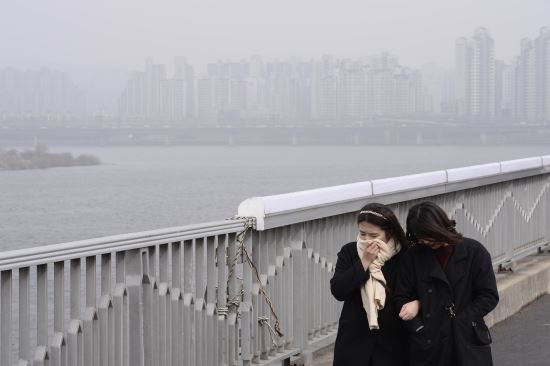 南韓民眾受不了來自中國的沙塵暴，以衣物遮壁口、鼻。 圖 : 翻攝自人民網 / 韓國頻道