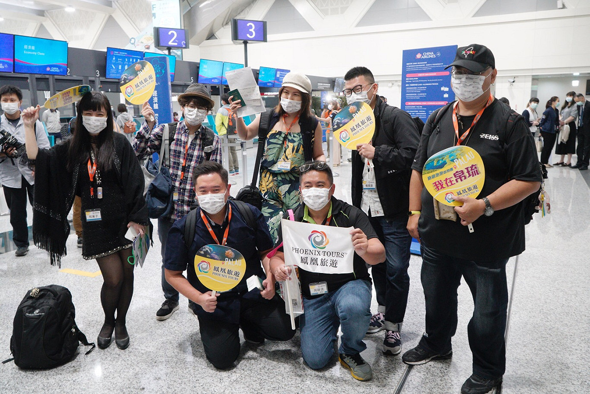 拿到PCR檢測陰性的旅客開心出示證明書，並陸續辦理登機手術，興奮的旅客並高喊：「帛琉！我來了！」。 圖：張良一/攝
