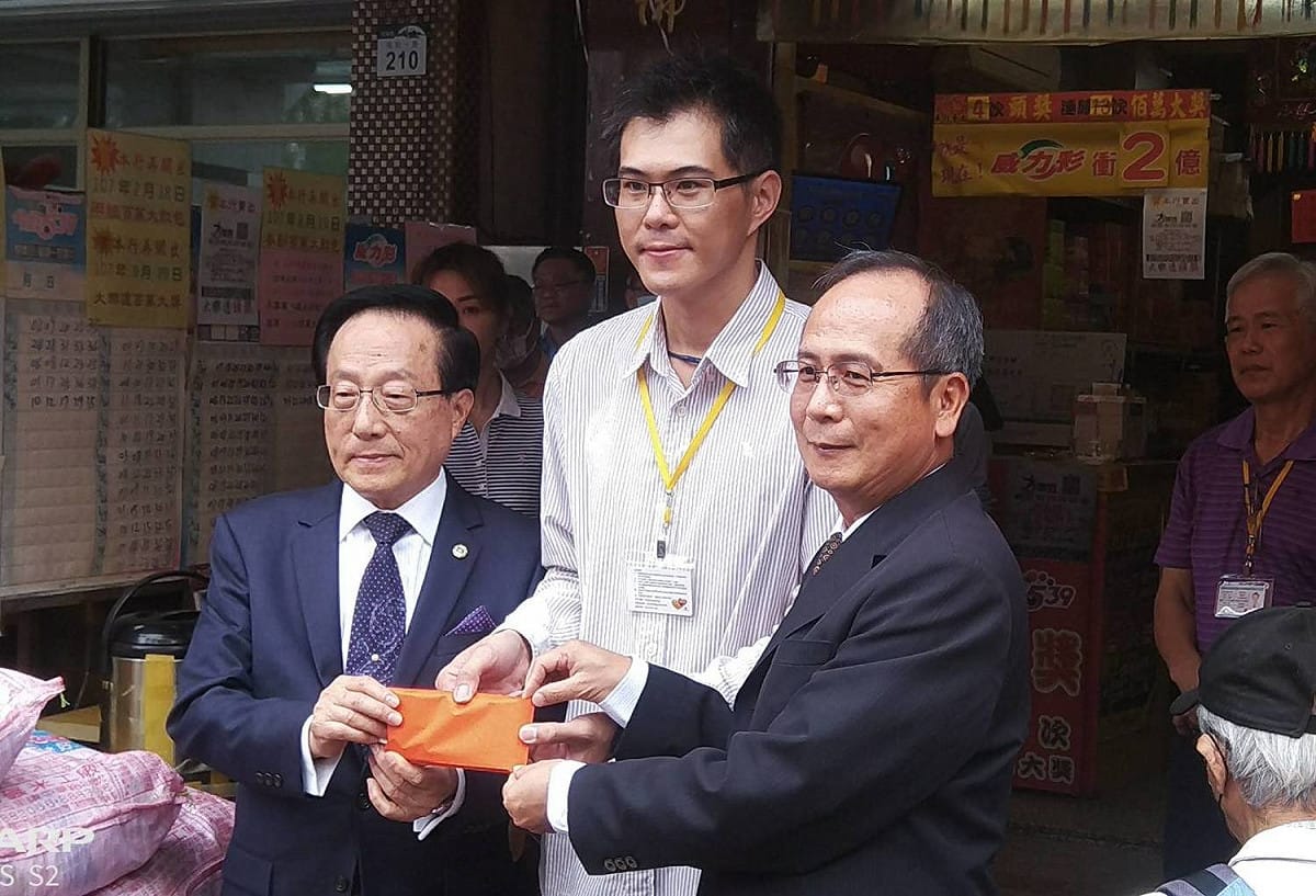 台彩董事黃志宜(左)、總經理謝志宏(右)轉交紅包、香油錢給經銷商。  圖：孫家銘/攝